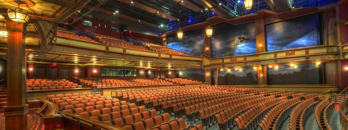 Large expo hall with tiered seating and stage lighting