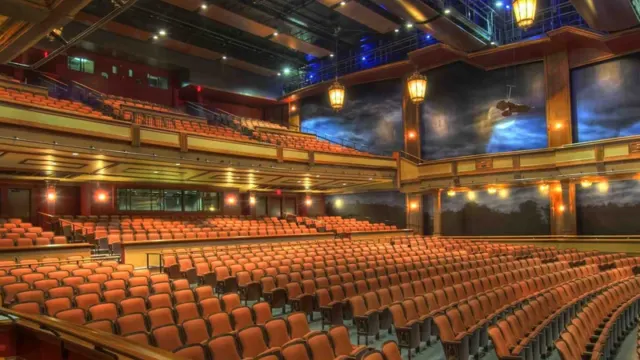 Large expo hall with tiered seating and stage lighting