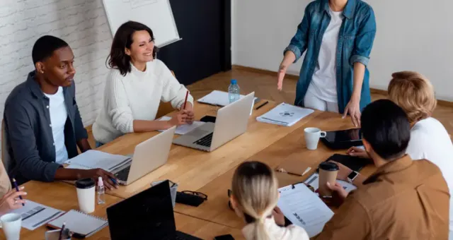Small group working on laptops around a large table